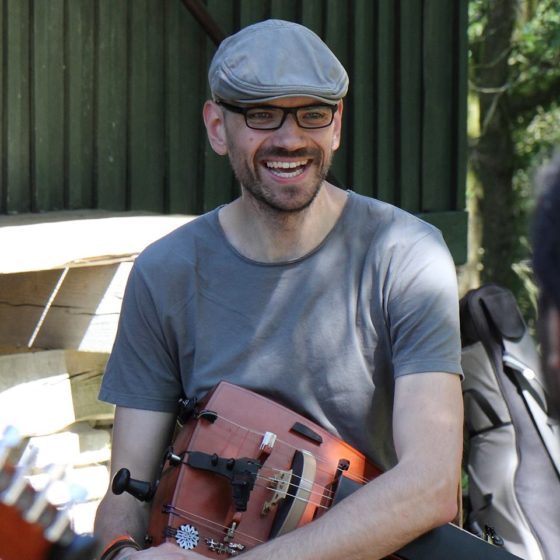 Ein Bild, das Person, Kleidung, Menschliches Gesicht, Gitarre enthält.
Automatisch generierte Beschreibung